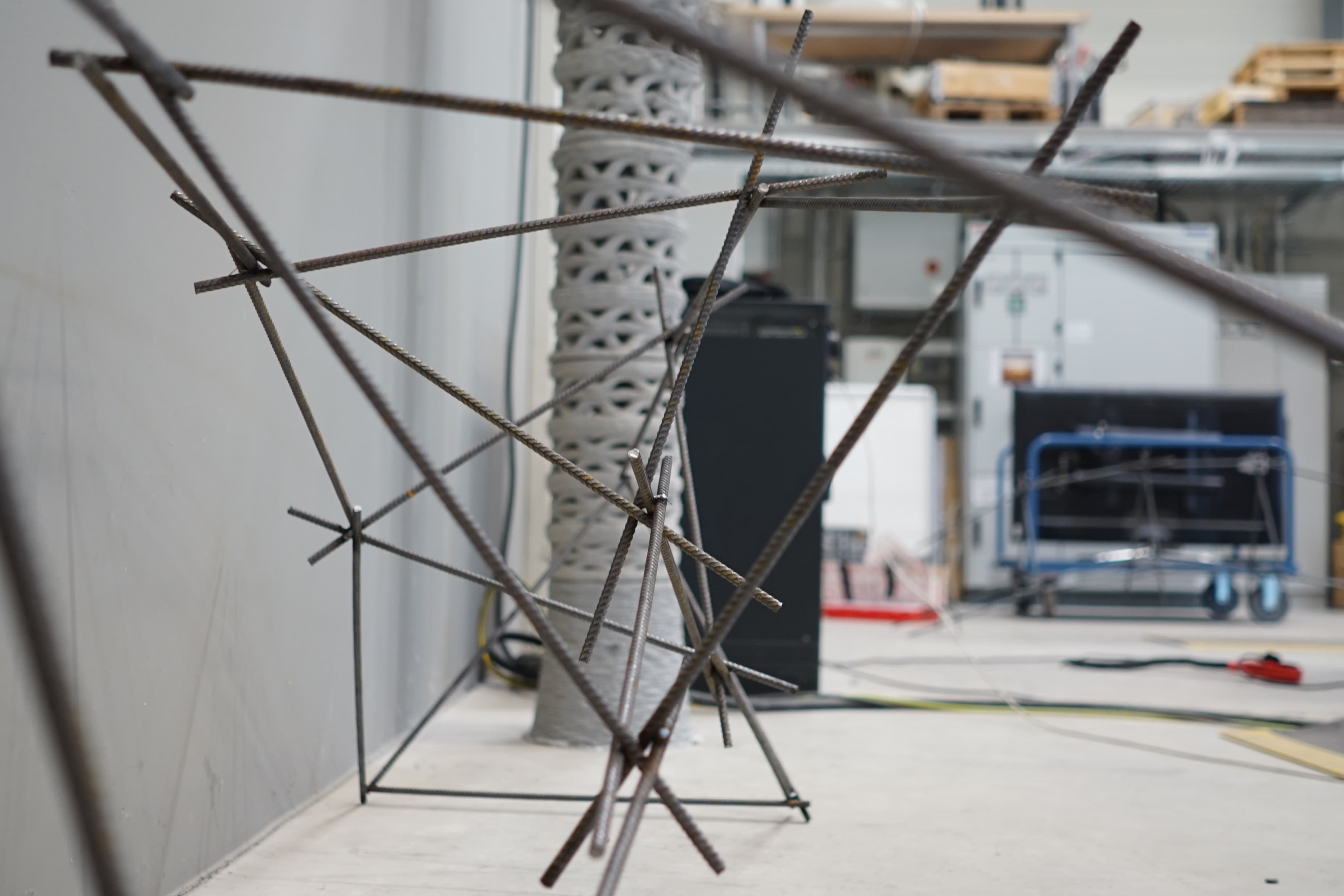KUKA Robotic Bridge Fabrication: The partially assembled rebar framework reveals how repeated triangular members build the bridge's structural rhythm.